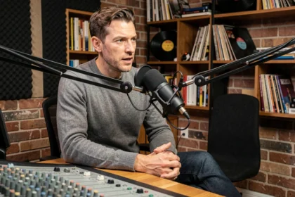 Podcaster français enregistrant un épisode dans un studio artisanal avec microphone professionnel et panneaux acoustiques